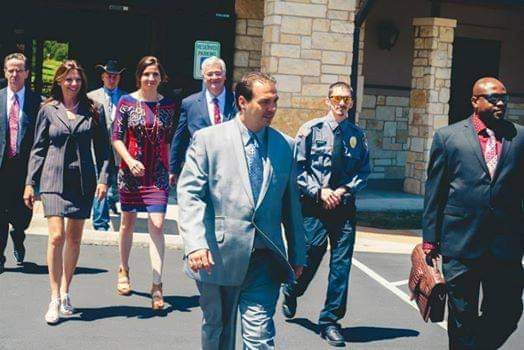 Security officer walking with a group of people in business attire