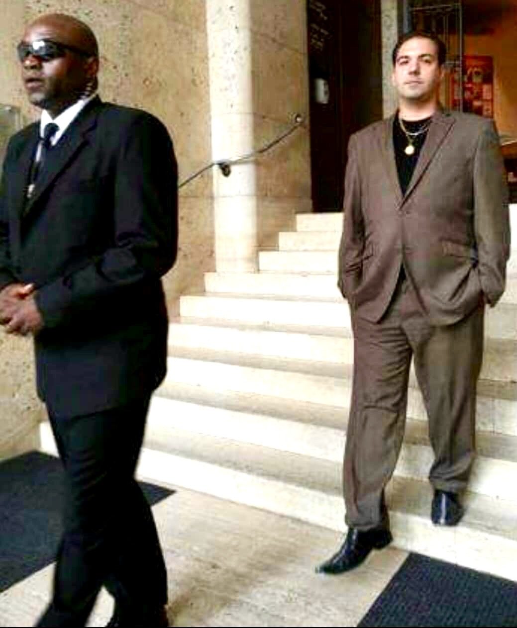 Two men in suits standing at a building entrance