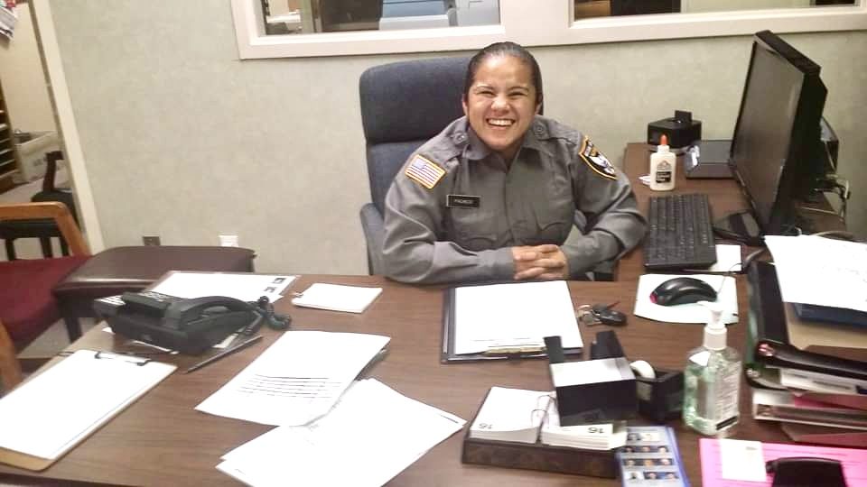 Uniformed security officer seated at an office desk