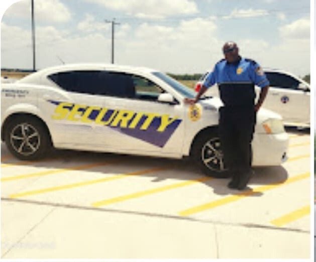Security officer standing beside a marked SECURITY car