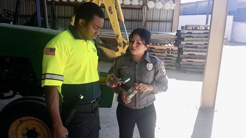 Security officer speaking with a worker at a warehouse yard